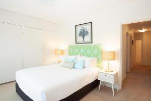 1 dormitorio blanco con 1 cama grande y 2 lámparas en Bayside Tranquility en Sídney