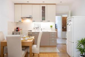 a kitchen with a table and a white refrigerator at Kennedy Apartment URBAN STAY in Zagreb