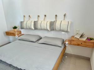 Apartamento Brisa de Menorca في سون بارك: سرير عليه مخدات في غرفه