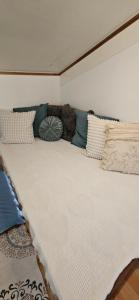 uma cama grande num quarto com almofadas em Experience tiny house living right at the beach, Vacation home em San Francisco