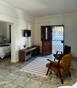 sala de estar con cama, silla y ventana en 50 on Alice, en King Williamʼs Town