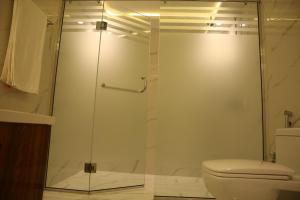 a bathroom with a glass shower with a toilet at Peshawar Barracks in Peshawar