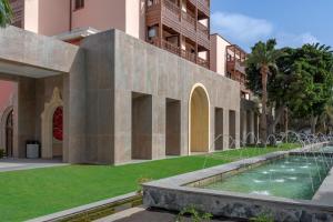 a courtyard of a building with a fountain at Santa Catalina, a Royal Hideaway Hotel in Las Palmas de Gran Canaria