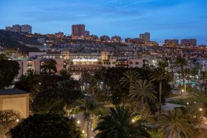 a city at night with buildings and palm trees at Santa Catalina, a Royal Hideaway Hotel in Las Palmas de Gran Canaria