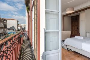 a room with a bed on a balcony at GuestReady - Cedofeita Pool Suite 3 in Porto