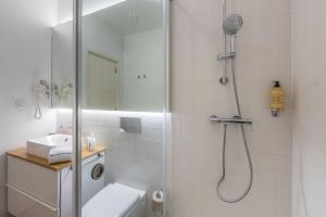 a bathroom with a shower with a toilet and a sink at GuestReady - Cedofeita Pool Suite 3 in Porto