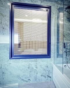 a bathroom with a window and a glass shower at ONKA OTELCİLİK TURİZM TİCARET LİMİTED ŞİRKETi in Istanbul