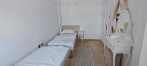 a hospital room with three beds and a mirror at Mıstık Otel in Cesme
