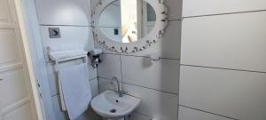 a white bathroom with a mirror and a sink at Mıstık Otel in Cesme