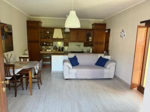 sala de estar y cocina con sofá y mesa en B&B Fiume, en Morino