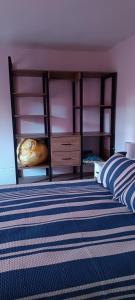 a bedroom with a bed with a blue and white stripes at La Casita II in Cochabamba