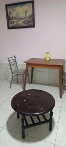 una mesa de madera y un taburete en una habitación con mesa y mesa en La Casita II, en Cochabamba