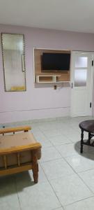 a room with a table and a tv on a wall at La Casita II in Cochabamba