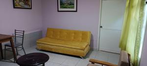 a yellow couch in a living room with a table at La Casita II in Cochabamba