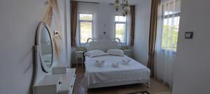 a bedroom with a white bed with two cups on it at Mıstık Otel in Cesme