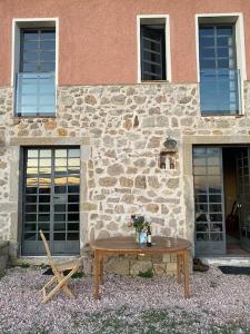 a wooden table in front of a stone building at Casa Vista Maremma Tuscany in Roccatederighi