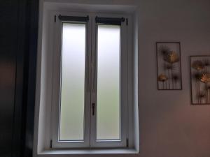 una ventana con cortinas blancas en una habitación en A due passi da Milano - Rho Fiera - Malpensa - Como en Saronno