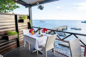 una mesa en una terraza con vistas al agua en Ocean's Edge Lodge Restaurant & Bar, en Roseau