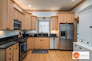 a kitchen with wooden cabinets and stainless steel appliances at Lake Life Getaway - Condo near downtown! in Douglas