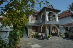 a house with a motorcycle parked in front of it at Mickey Homestay in Thekkady