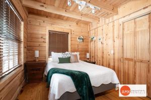 una camera da letto con un letto in una stanza di legno di Wonderful Log Cabin near private beach and lake access a Saugatuck