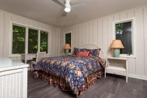 a bedroom with a bed and chairs and windows at Beach View Cottage - On the Lake in Holland