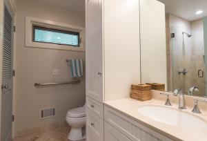 a white bathroom with a sink and a toilet at Beach View Cottage - On the Lake in Holland +38 photos