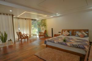 ein Schlafzimmer mit einem Bett und einem Tisch und Stühlen in der Unterkunft Mickey Homestay in Thekkady