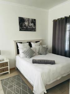 een slaapkamer met een groot bed met witte lakens en kussens bij 50 on Alice in Koning Willemstad