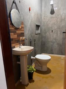 uma casa de banho com um lavatório e um WC em Pousada Recanto do Tucano em Cavalcante