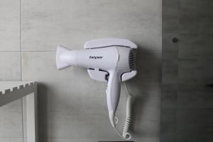 a hair dryer hanging on a wall in a bathroom at la luna blu malpensa camera singola zen in Somma Lombardo