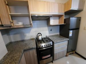 a small kitchen with a stove and a refrigerator at Ámbar B3-P15-TC in Cochabamba