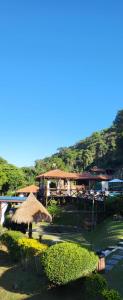 a patio with an umbrella and a building with a mountain at Pousada do Coura in Pouso Alto