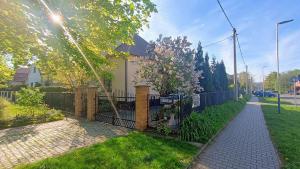 a fence in front of a house with a sidewalk at Rodinný Penzion Karin in Ostrava