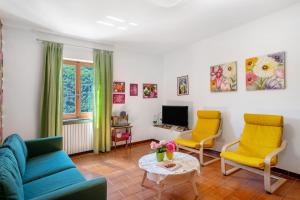 uma sala de estar com duas cadeiras e uma televisão em La casa di Bosco em Casanova Lerrore