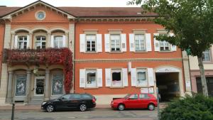 dos coches estacionados frente a un edificio en Pension Anna, en Rastatt