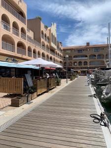 a wooden boardwalk in front of a large building at La Cigale Varoise - Hyères La Plage in Hyères