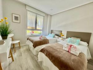 Ένα ή περισσότερα κρεβάτια σε δωμάτιο στο Apartamento VERDEMAR SUANCES, con parking, piscinas y pádel