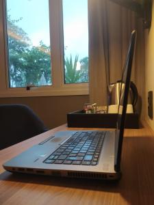 a laptop computer sitting on top of a wooden table at Novotel Sao Jose dos Campos in São José dos Campos