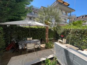 un patio con una sombrilla, una mesa y una palmera en Seafront, en San Benedetto del Tronto