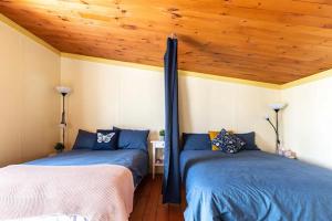 Duas camas num quarto com tectos em madeira em LAO em Notre-Dame-Des-Bois