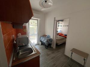 una pequeña cocina con fregadero y un dormitorio en Seafront, en San Benedetto del Tronto