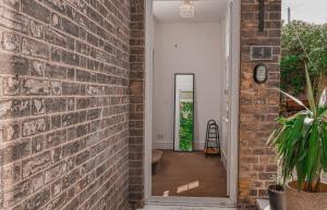a brick hallway with a brick wall and a mirror at Hampton Court Cottage in Hampton