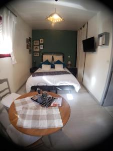 Una habitación de hotel con una cama y una mesa con en Maison de Paille, en Ceton