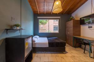 a bedroom with a bed and a table and a window at Living Hotel in Medellín
