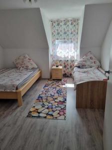 Habitación pequeña con 2 camas y alfombra. en Gasthaus Weigl, en Großmehring
