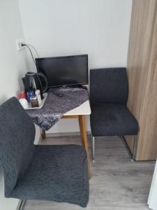 einen Schreibtisch mit zwei Stühlen und einem Computer darauf in der Unterkunft Gasthaus Weigl in Großmehring