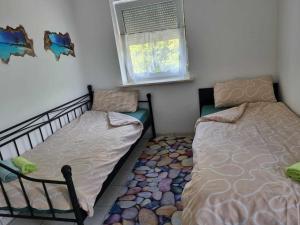 a bedroom with two twin beds and a window at Monteurwohnung Weigl in Großmehring