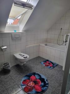 a bathroom with a toilet and a bath tub at Gasthaus Weigl in Großmehring