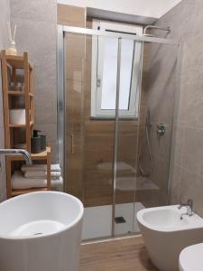 een badkamer met een douche, een bad en een wastafel bij GiglioApartment Etna Mare in Aci Castello